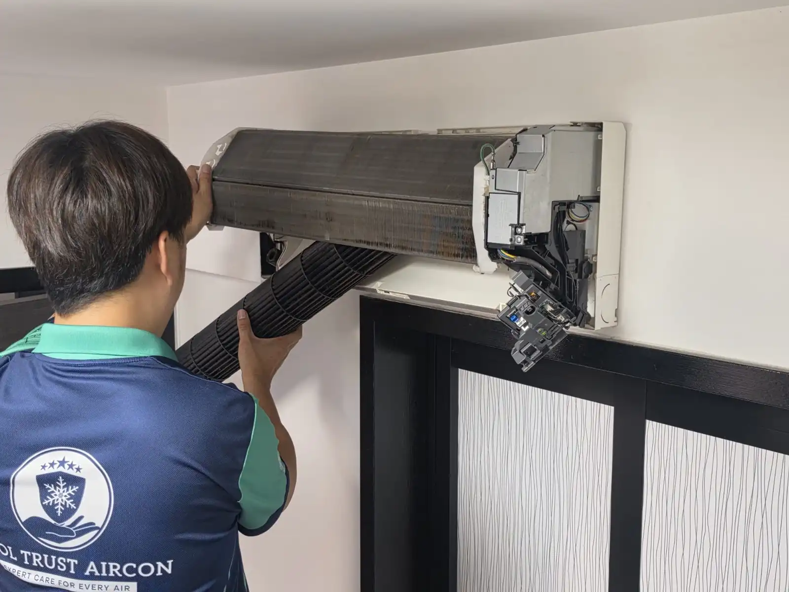 CoolTrust technician cleaning internal aircon components